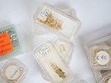 many different types of jewelry in plastic containers on the table