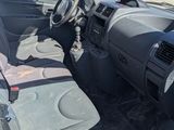 the interior of a car with the door open and the driver ' s seat down