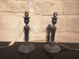 deux bougies posées sur une table près d'un mur de briques