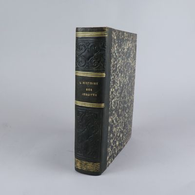 un livre noir et or posé sur une table blanche