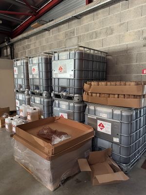 de nombreux conteneurs et cartons dans un entrepôt, avec des cartons posés à même le sol