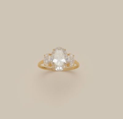 an oval white diamond ring with three pear shaped diamonds on the band