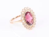 a close up of a pink tourmaline and diamond ring on a white background