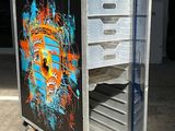un chariot métallique orné d'une peinture, dans un parking
