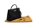 a black handbag sitting on top of a yellow blanket