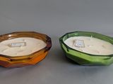 two candles are sitting side by side on a gray surface