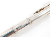 a silver pen that is laying on a white surface