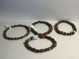trois bracelets composés de perles marron et noires sur un fond blanc