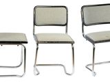 quatre chaises sont alignées sur un fond blanc