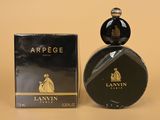 gros plan d'un flacon de parfum à côté d'une boîte