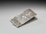 pince à billets en argent ornée d'un motif floral sur fond blanc