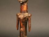 une statue en bois représentant un homme avec un visage et des jambes