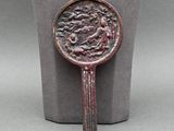 une image représentant un miroir en bronze posé sur un socle