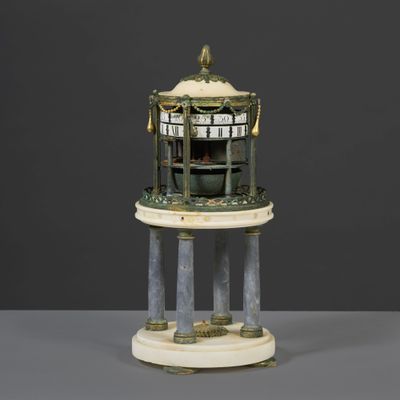 an image of a clock on a pedestal on a table