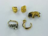 three gold and silver jewelry pieces on a white surface