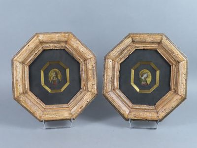 une paire de tableaux encadrés représentant un homme et une femme dans un cercle