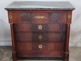 an antique chest of drawers with marble top and brass handles