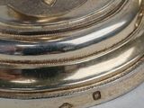 a close up of a silver plate with a flower on it