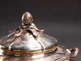 a silver plate with a lid that has a flower on it