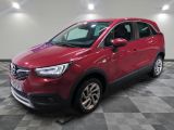 une voiture rouge est garée dans une grande pièce au sol en damier