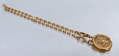 a close up of a gold necklace with a medallion on it