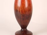 a vase that is sitting on a stand on a white surface