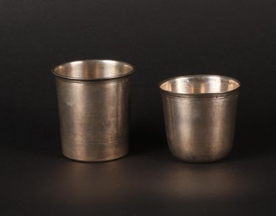 two silver cups sitting side by side on a black surface