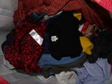 a pile of clothes in a bag on a bed