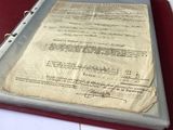 un vieux document posé sur un classeur, lui-même posé sur une table
