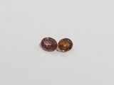 a pair of pink and yellow sapphires on a white surface