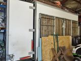 une photo d'un garage dans lequel se trouvent un tracteur et une remorque