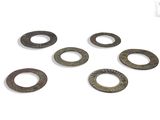 six pieces of old metal washers on a white surface