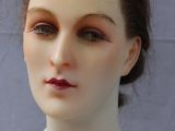 a white mannequin head with red lipstick on it