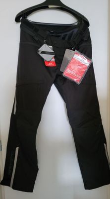 black pants hanging on a hanger in a closet next to a door
