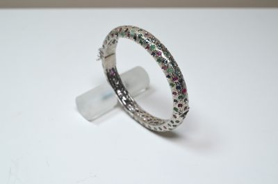 bague en argent ornée de pierres multicolores posées sur un fond blanc