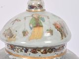 a vase with a lid that has a picture of a man on it