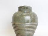 a green vase that is sitting on a white surface
