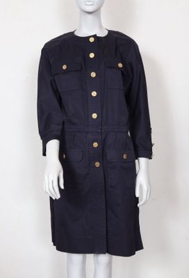 le mannequin porte une robe noire avec des boutons dorés