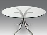 une table ronde en verre avec des pieds en métal et un plateau en verre