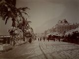 a black and white photo of people walking down a snowy street