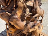 a large wooden sculpture of horses on a wooden table