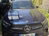 La Mercedes GLE est garée dans l'allée, à côté d'un mur de briques.