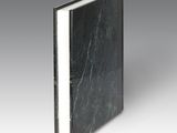 a close up of a book with a black cover and white pages