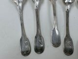 six spoons are lined up in a row on a white surface