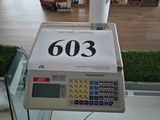 une caisse enregistreuse dans un magasin, sur laquelle est apposée une étiquette de prix