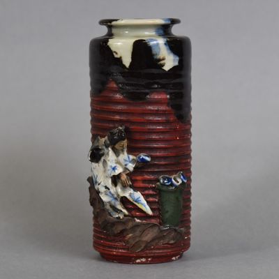 un vase orné d'un chien et d'un oiseau