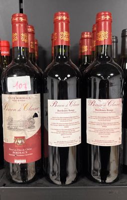 several bottles of red wine sit on a shelf in a store