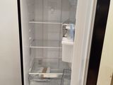 a black refrigerator with its door open in a room