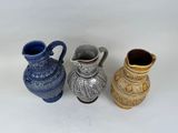three vases sitting next to each other on a white surface
