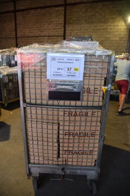un chariot sur lequel se trouvent quelques cartons dans un entrepôt